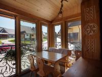 een afgeschermde veranda met een houten tafel en stoelen bij Willa Pod Groniem in Ciche Małe