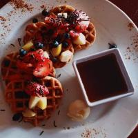 un plato de gofres con sirope y fruta. en Casa Blanca San Miguel, en San Miguel de Allende