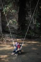 due ragazze su un'altalena di corda in un fiume di Lanna Resort Chiang Mai a Ban Dong