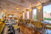 マラケシュにあるJanat Al Atlas Resort & Spaのテーブルと椅子と大きな窓のあるレストラン