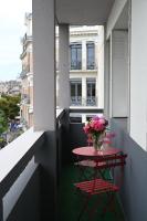 a table and chairs on a balcony with a vase of flowers at Grand appartement cosy-Hyper Centre-Place Verdun in Tarbes