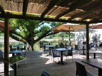 Un patio con mesas y sillas y un árbol. en Logis Hôtel Les Vieilles Granges, en Granges-Les-Beaumont