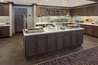 una cocina grande con armarios marrones y una barra grande en Homewood Suites By Hilton Ronkonkoma, en Ronkonkoma