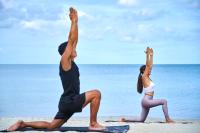 a man and woman doing yoga on the beach at Sheraton Samui Resort in Chaweng Noi Beach