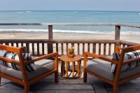 two chairs and a table on a balcony overlooking the beach at Sheraton Samui Resort in Chaweng Noi Beach