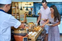 a group of people standing around a buffet of food at Sheraton Samui Resort in Chaweng Noi Beach