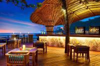 a restaurant with tables and chairs and a view of the ocean at Sheraton Samui Resort in Chaweng Noi Beach