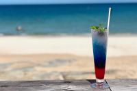 a drink sitting on a table in front of the beach at Sheraton Samui Resort in Chaweng Noi Beach