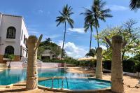 a resort swimming pool with palm trees in the background at Sheraton Samui Resort in Chaweng Noi Beach