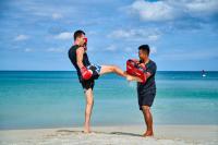 two men standing on a beach with their legs in the sand at Sheraton Samui Resort in Chaweng Noi Beach