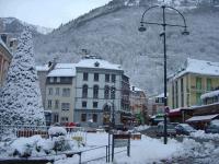 a snow covered city with a christmas tree and buildings at Bel appt 3 * plein Centre ville 4 pers. + balcon in Cauterets