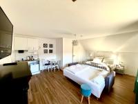 a large bedroom with a large bed and a kitchen at VILLA ORCHARD Frankfurt in Zeilsheim