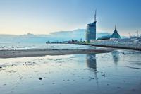 a beach with buildings in the background and the ocean at Atlantic Hotel Sail City in Bremerhaven