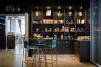 a bar in a store with green stools at Atlantic Hotel Sail City in Bremerhaven