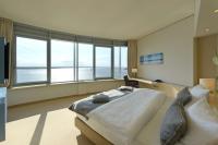 a bedroom with a large bed and large windows at Atlantic Hotel Sail City in Bremerhaven