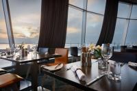 a restaurant with tables and chairs with a view of the ocean at Atlantic Hotel Sail City in Bremerhaven