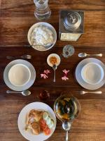 TanjungtirtoにあるOhmmstay - Rumah Pendopoの食べ物の皿とご飯の入った椀が置かれた木製のテーブル