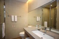a bathroom with a sink and a toilet and a mirror at Grace Hotel in Zhonghe