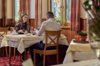 um homem e uma mulher sentados numa mesa num restaurante em Hotel Das Bayerwald em Lam