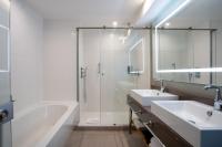 a bathroom with a tub and two sinks and a shower at Courtyard by Marriott Paris Porte de Versailles in Issy-les-Moulineaux