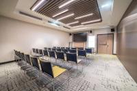 a conference room with chairs and a podium and a screen at Courtyard by Marriott Paris Porte de Versailles in Issy-les-Moulineaux