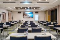 a conference room with tables and chairs and a screen at Courtyard by Marriott Paris Porte de Versailles in Issy-les-Moulineaux