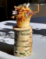 un cupcake appoggiato in cima a un ceppo d'albero di Farlam Hall Hotel & Restaurant a Brampton