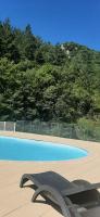 a blue swimming pool with a black object in the middle at T2 au cœur de la nature de Digne in Digne-les-Bains