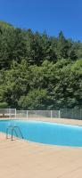 a blue swimming pool with a fence and trees at T2 au cœur de la nature de Digne in Digne-les-Bains