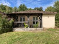 a small house with a porch with green chairs at F1 noir&#47;anis, avec terrasse couverte et jardin (E) in Compreignac