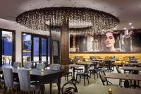 Un restaurante con mesas y sillas y una gran lámpara de araña. en The Peregrine Omaha Downtown Curio Collection By Hilton, en Omaha