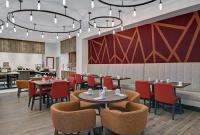 a dining room with tables and chairs and a bar at Hilton Garden Inn Madison Huntsville Airport in Madison