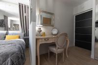 a bedroom with a desk with a clock and a bed at Le Petit Prince- Studio cosy 2 pers -métro Valmy in Lyon