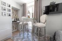 a dining room with two stools and a table and chairs at Le Petit Prince- Studio cosy 2 pers -métro Valmy in Lyon