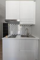 a kitchen with white cabinets and a sink at Le Petit Prince- Studio cosy 2 pers -métro Valmy in Lyon