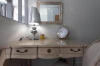 a desk with a clock and a lamp and a mirror at Le Petit Prince- Studio cosy 2 pers -métro Valmy in Lyon