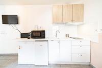 a kitchen with white cabinets and a microwave at Le petit Montel- studio avec garage-métro Valmy in Lyon