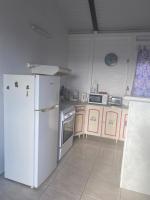 a kitchen with a white refrigerator and a stove at magnifique t2 de charme in Ravine Braie