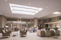 Un vestíbulo con sillas y mesas y un tragaluz. en Doubletree by Hilton Laurel, MD, en Laurel