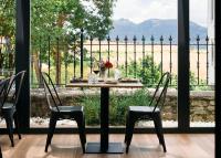 een tafel en stoelen voor een groot raam bij El Amparo de Narcisa in Oteo