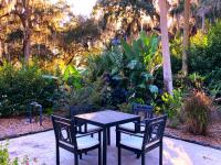 einen Tisch und zwei Stühle neben einem Garten in der Unterkunft Retreat at Crystal Manatee in Crystal River