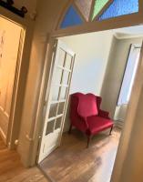 einem roten Stuhl in einem Raum neben einer Tür in der Unterkunft NIMES FOULC in Nîmes