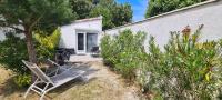 a couple of chairs sitting in the yard of a house at La Remigeasse in Dolus-d&#39;Oléron