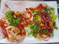 une assiette de nourriture avec une salade et un sandwich dans l'établissement Pension Mojito Senftenberg, à Senftenberg