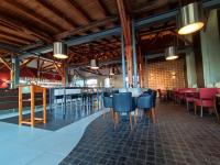a restaurant with blue chairs and tables and a brick wall at Hostel am GÜTERBAHNHOF in Neubrandenburg