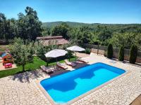 a swimming pool in a yard with umbrellas at Villa Prima Natura, Imotski private pool in Imotski