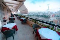 Un balcón con mesas y sillas y vista a una ciudad. en Borg El Thaghr Hotel, en Alejandría