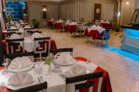 un grupo de mesas y sillas con mesas rojas y blancas en Borg El Thaghr Hotel, en Alejandría