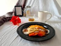 a plate of food on a bed with a cell phone at Hotel Vista Laguna Bacalar in Bacalar