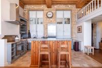 a kitchen with a counter with stools and a clock on the wall at Le Cocon Pacôme Les Autres in Lyon